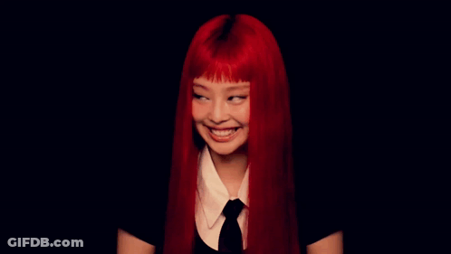 A Woman With Red Hair Is Smiling In A Black Background GIF