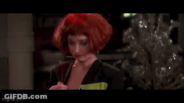 A Woman With Red Hair Is Standing In Front Of A Christmas Tree And Says Typical GIF