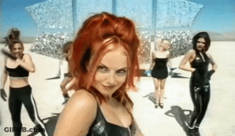 A Woman With Red Hair Is Standing In Front Of A Group Of Women In Black Latex . GIF