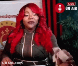 A Woman With Red Hair Is Standing In Front Of A Microphone And Talking Into It . GIF