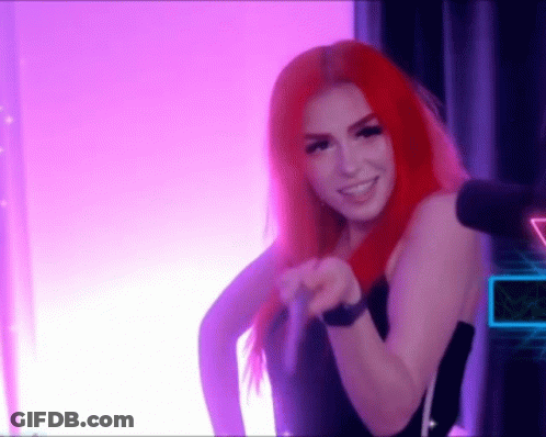 A Woman With Red Hair Is Standing In Front Of A Microphone . GIF