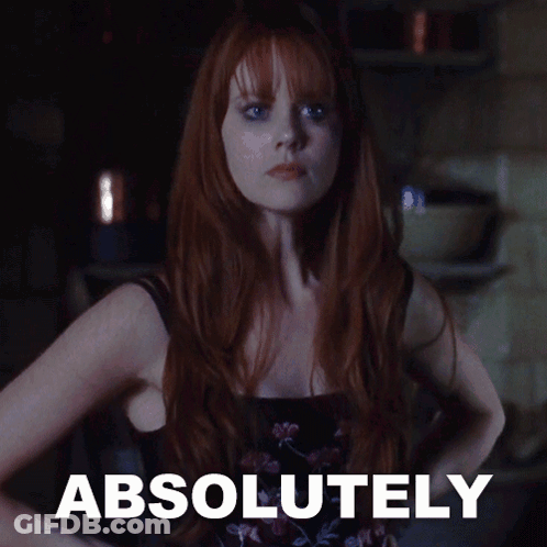 A Woman With Red Hair Is Standing In Front Of A Sign That Says " Absolutely " GIF