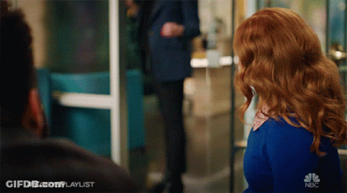 A Woman With Red Hair Is Standing In Front Of A Sign That Says #Zoeysplaylist GIF
