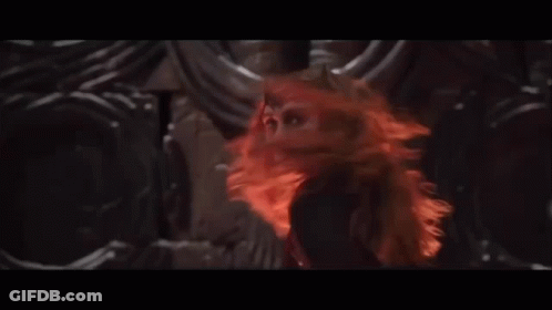 A Woman With Red Hair Is Surrounded By Horns In A Dark Room GIF