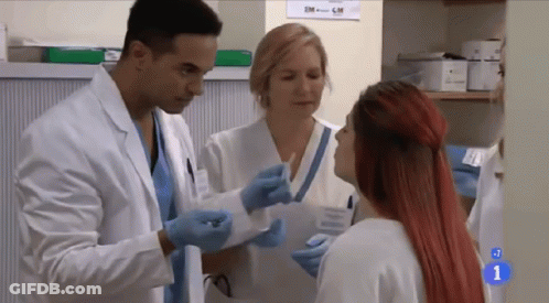 A Woman With Red Hair Is Talking To A Doctor In A Hospital GIF