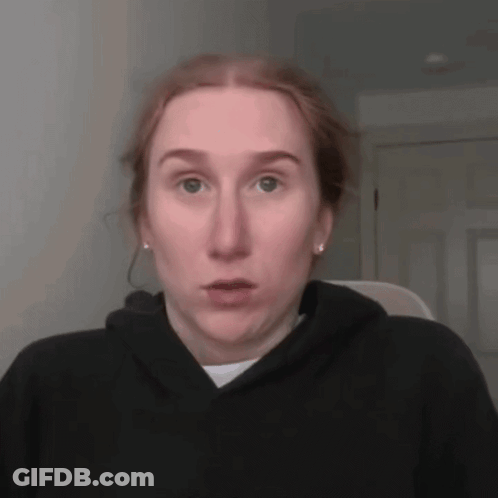 A Woman With Red Hair Is Wearing A Black Hoodie GIF