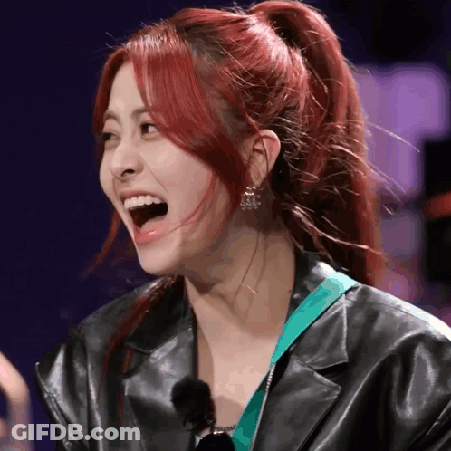 A Woman With Red Hair Is Wearing A Black Jacket GIF
