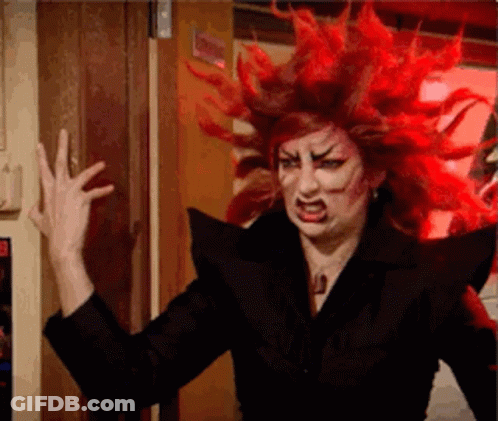 A Woman With Red Hair Is Wearing A Black Jacket And Making A Funny Face . GIF