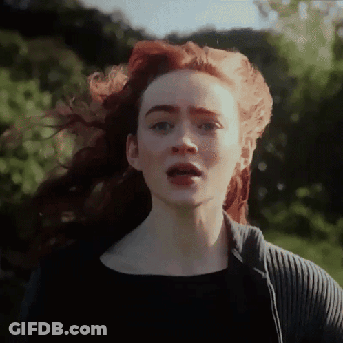 A Woman With Red Hair Is Wearing A Black Shirt GIF