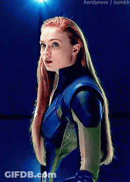A Woman With Red Hair Is Wearing A Blue And Green Suit GIF