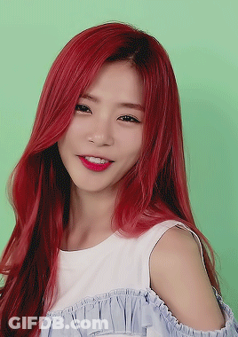 A Woman With Red Hair Is Wearing A Blue And White Off The Shoulder Top GIF