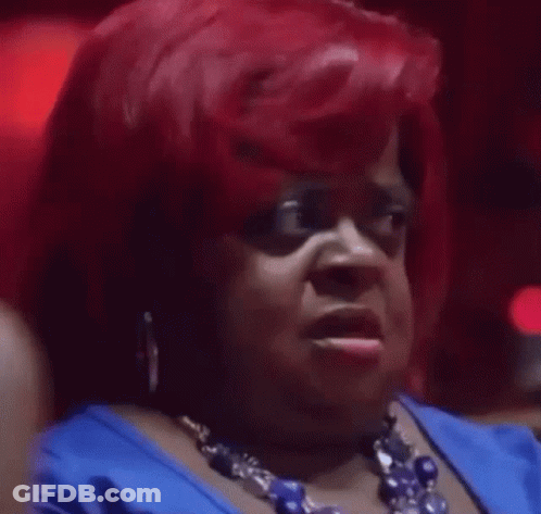 A Woman With Red Hair Is Wearing A Blue Dress And A Blue Necklace . GIF