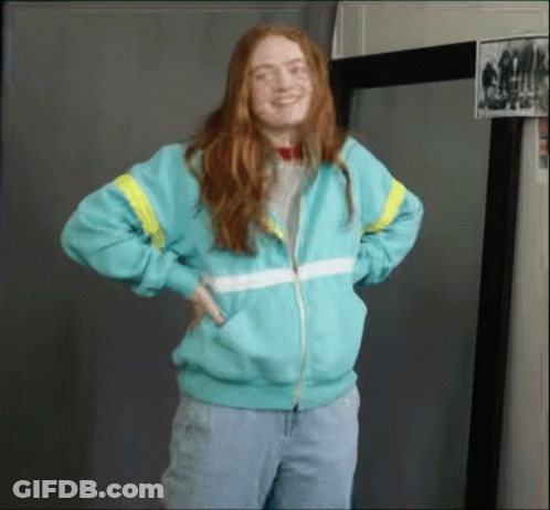 A Woman With Red Hair Is Wearing A Blue Jacket GIF