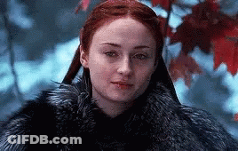 A Woman With Red Hair Is Wearing A Fur Coat And Standing In The Snow . GIF