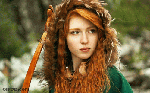 A Woman With Red Hair Is Wearing A Fur Hood GIF