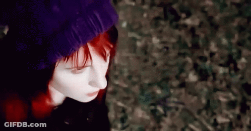 A Woman With Red Hair Is Wearing A Purple Beanie GIF