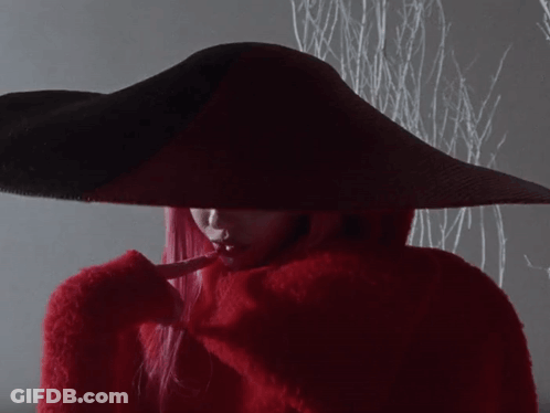 A Woman With Red Hair Is Wearing A Red Hat GIF