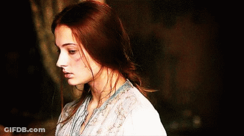 A Woman With Red Hair Is Wearing A White Blouse GIF
