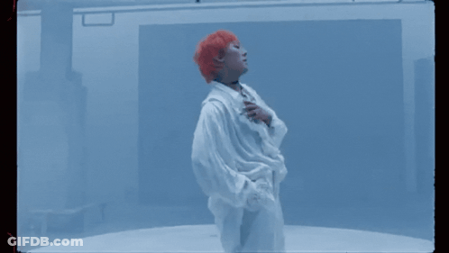 A Woman With Red Hair Is Wearing A White Shirt And A Choker . GIF