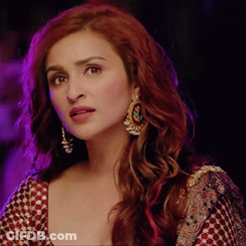 A Woman With Red Hair Is Wearing Earrings GIF