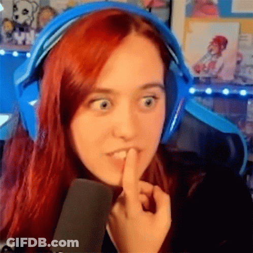 A Woman With Red Hair Is Wearing Headphones And Making A Funny Face . GIF