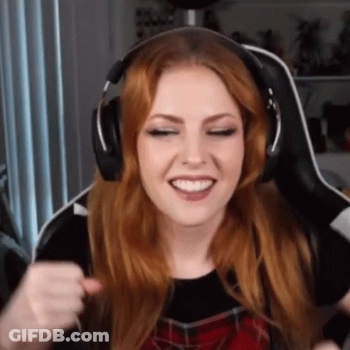 A Woman With Red Hair Is Wearing Headphones And Smiling While Sitting In A Chair . GIF