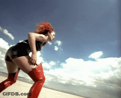 A Woman With Red Hair Is Wearing Red Boots GIF