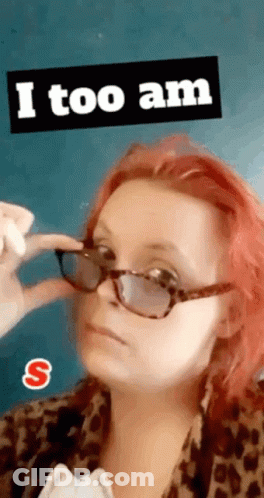 A Woman With Red Hair Is Wearing Sunglasses And A Sticker That Says I Too Am GIF