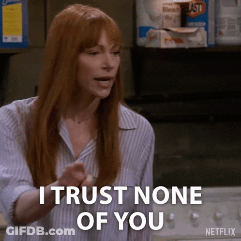 A Woman With Red Hair Says " I Trust None Of You " In Front Of A Laundry Machine . GIF