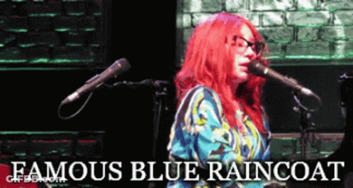 A Woman With Red Hair Singing Into A Microphone With The Words Famous Blue Raincoat Above Her GIF