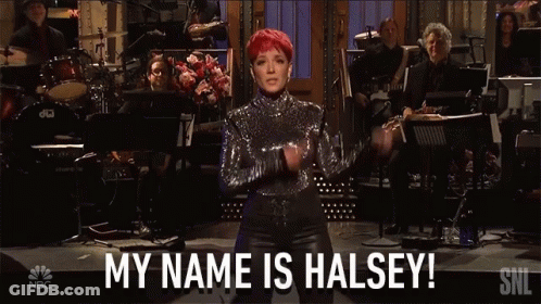 A Woman With Red Hair Stands In Front Of An Orchestra And Says Her Name Is Halsey GIF