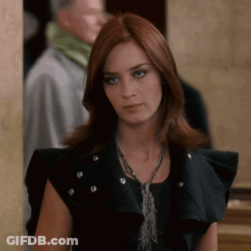A Woman With Red Hair Wearing A Black Vest GIF