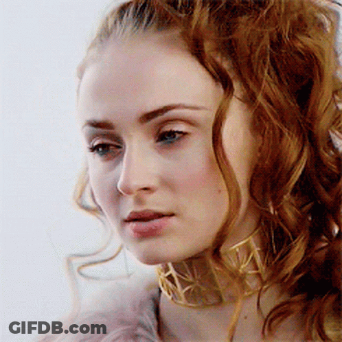 A Woman With Red Hair Wearing A Gold Choker GIF