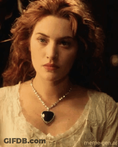A Woman With Red Hair Wearing A Heart Shaped Pendant GIF