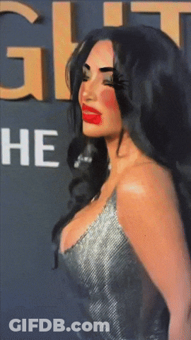 A Woman With Red Lips Is Standing In Front Of A Sign That Says ' He ' GIF