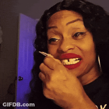 A Woman With Red Lipstick And A Black Shirt With The Letter V On It GIF