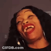 A Woman With Red Lipstick And Hoop Earrings Is Laughing With Her Eyes Closed . GIF
