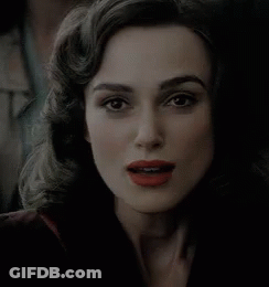 A Woman With Red Lipstick Is Smiling And Looking At The Camera GIF