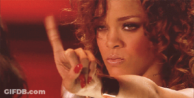 A Woman With Red Nail Polish Is Looking At Herself In The Mirror GIF