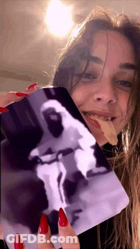 A Woman With Red Nails Is Holding A Card With A Picture Of An Astronaut On It GIF