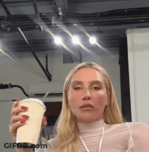 A Woman With Red Nails Is Holding A Cup In Her Right Hand GIF
