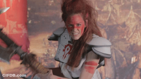 A Woman With Red Paint On Her Face Is Holding A Large Sword GIF
