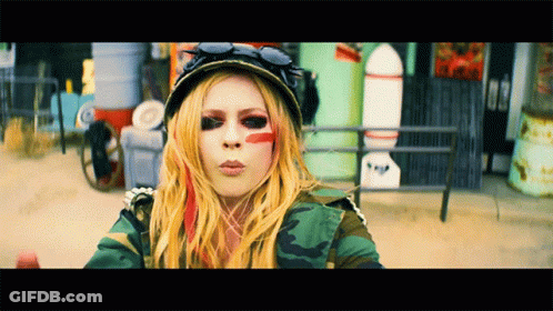 A Woman With Red Paint On Her Face Is Wearing A Camo Jacket GIF