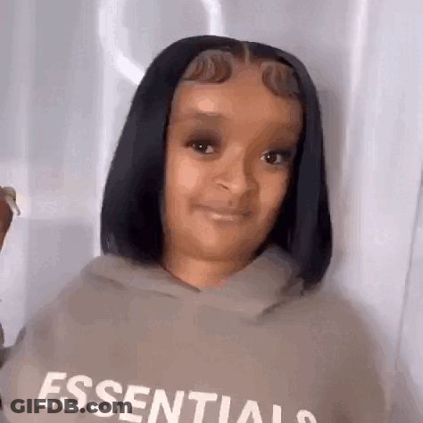 A Woman With Short Black Hair Is Wearing A Hoodie And Smiling . GIF