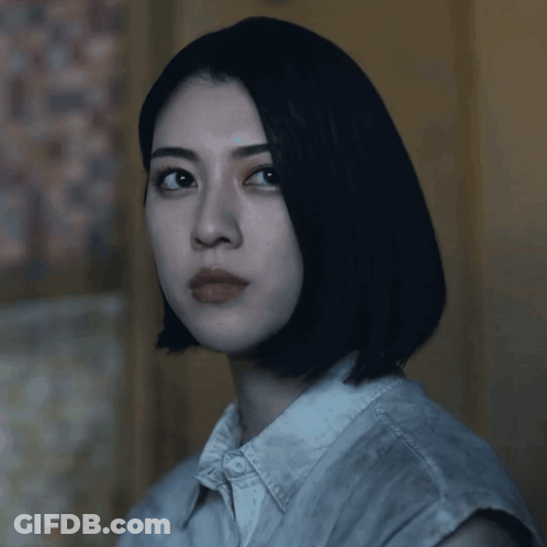 A Woman With Short Black Hair Looks At The Camera GIF