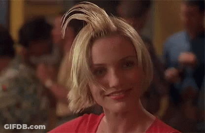A Woman With Short Blonde Hair Is Making A Funny Face . GIF