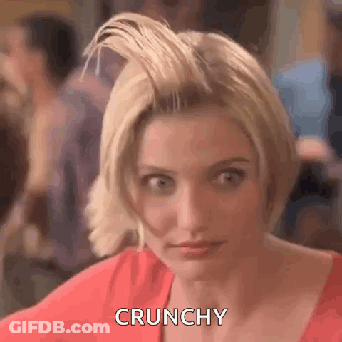 A Woman With Short Blonde Hair Is Making A Funny Face And Saying Crunchy . GIF