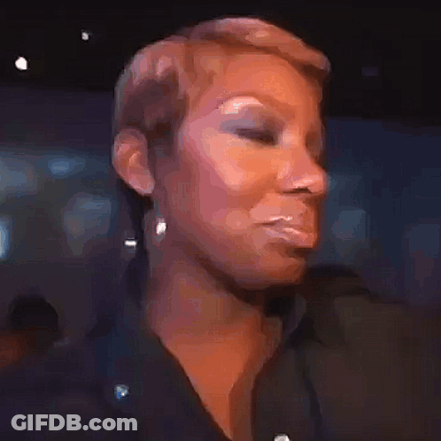 A Woman With Short Hair Is Making A Funny Face While Wearing A Black Shirt And Earrings . GIF