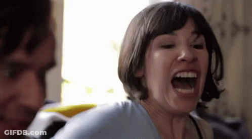 A Woman With Short Hair Is Screaming With Her Mouth Open . GIF