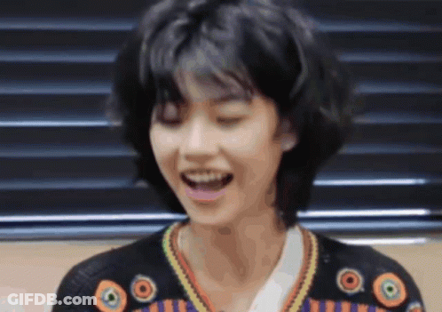 A Woman With Short Hair Is Smiling With Her Eyes Closed GIF